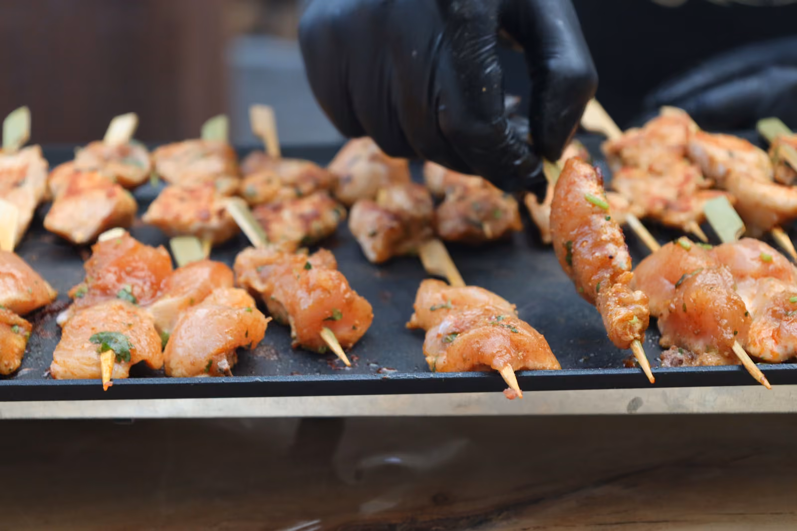 Brochettes de poulet mariné Brochettes de poulet mariné aux épices en train de griller sur une plancha