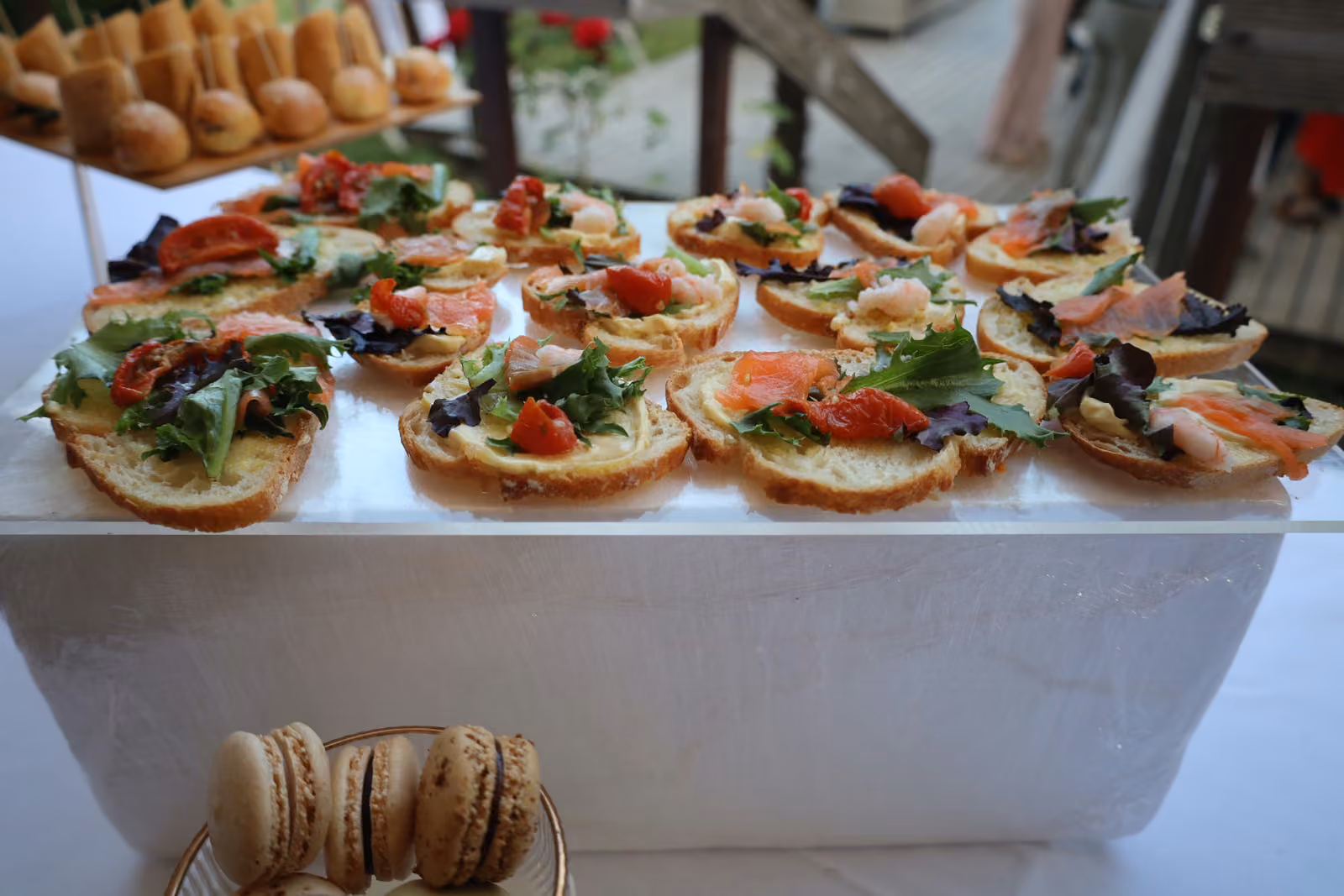 Bruschettas au saumon Bruschettas au saumon fumé, tomate séchée et roquette sur un présentoir blanc
