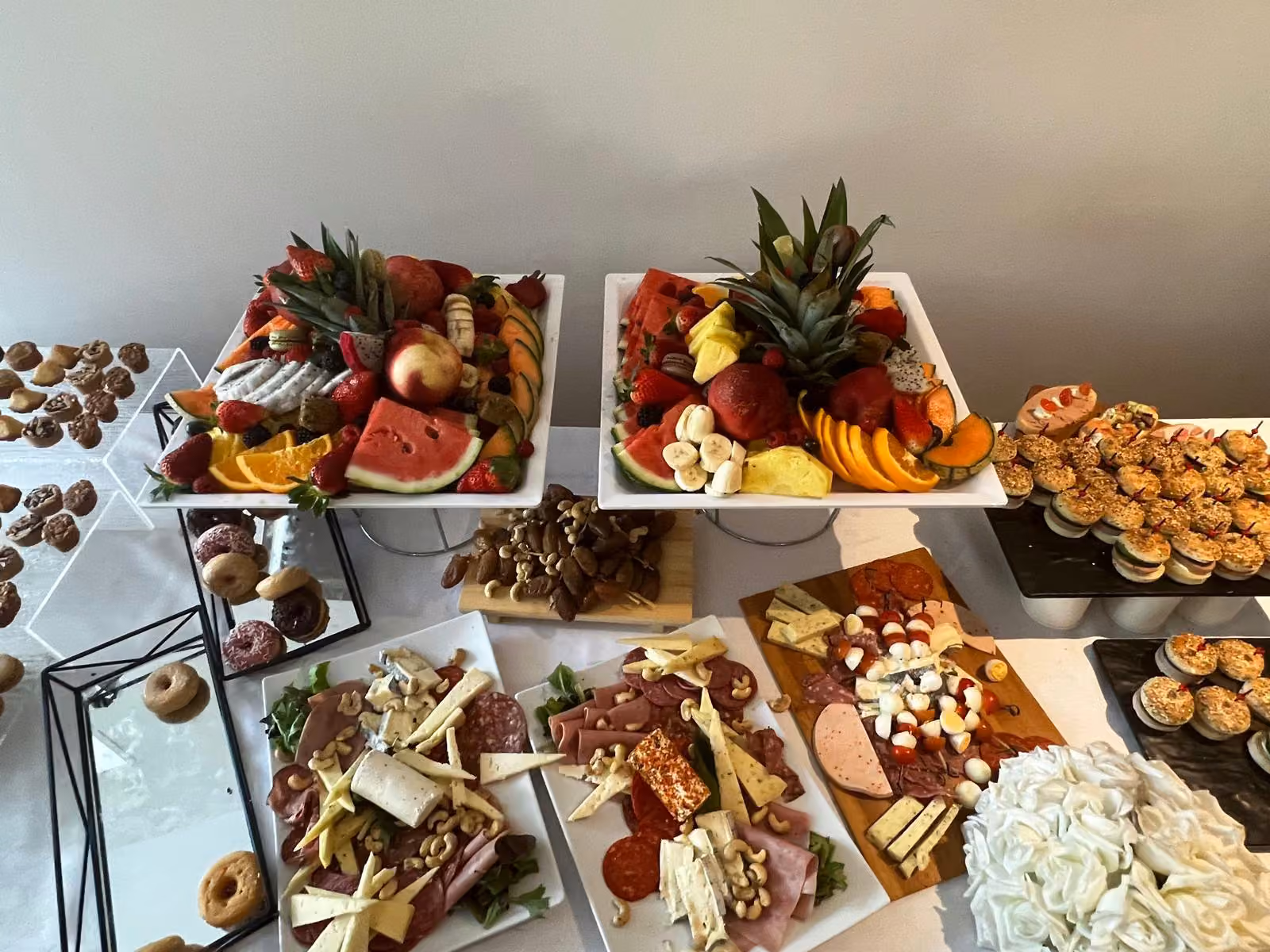 Buffet fruits, fromages et charcuterie Buffet avec plateaux de fruits et ananas, fromages, charcuterie et donuts