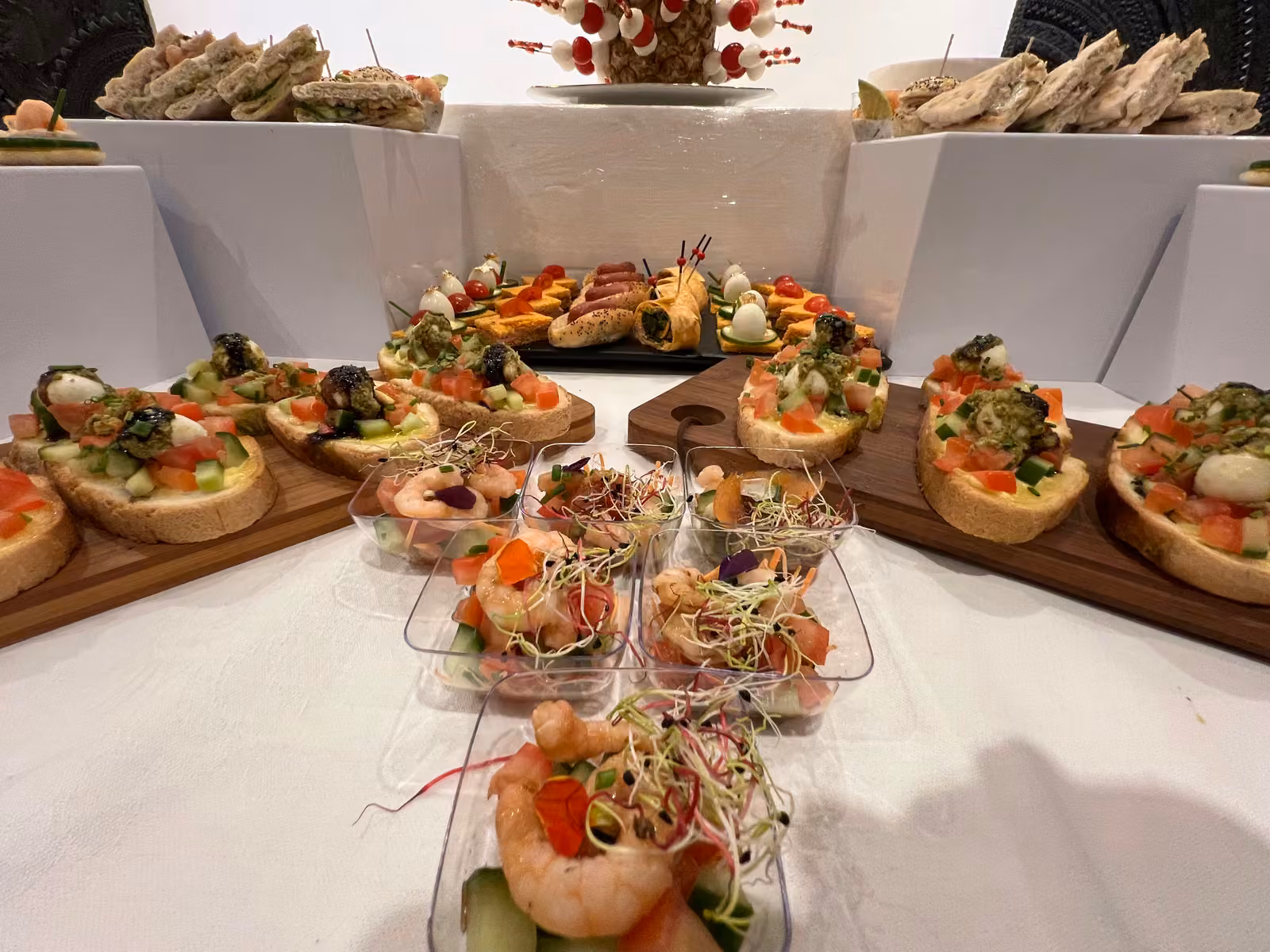 Canapés et verrines aux crevettes Canapés et verrines aux crevettes et jeunes pousses disposés en étoile sur planches en bois