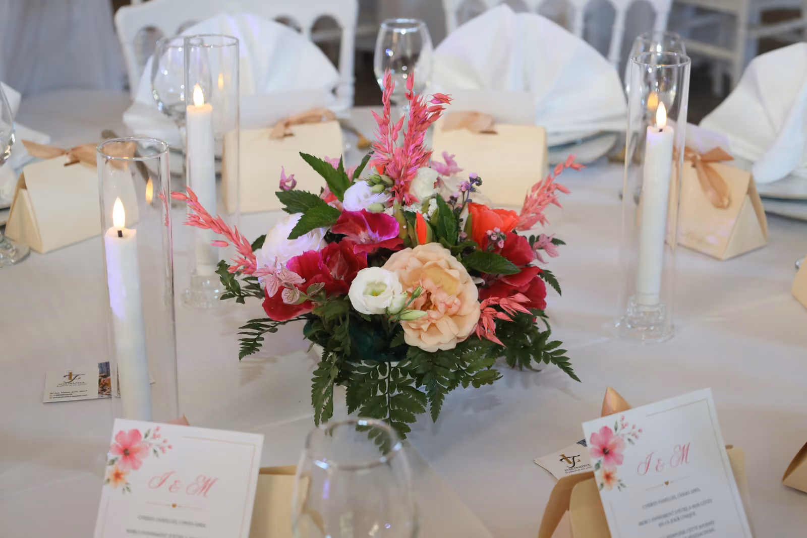 Centre de table et boîtes à dragées Centre de table de mariage : bouquet rose et fuchsia, bougies, boîtes à dragées et menus imprimés