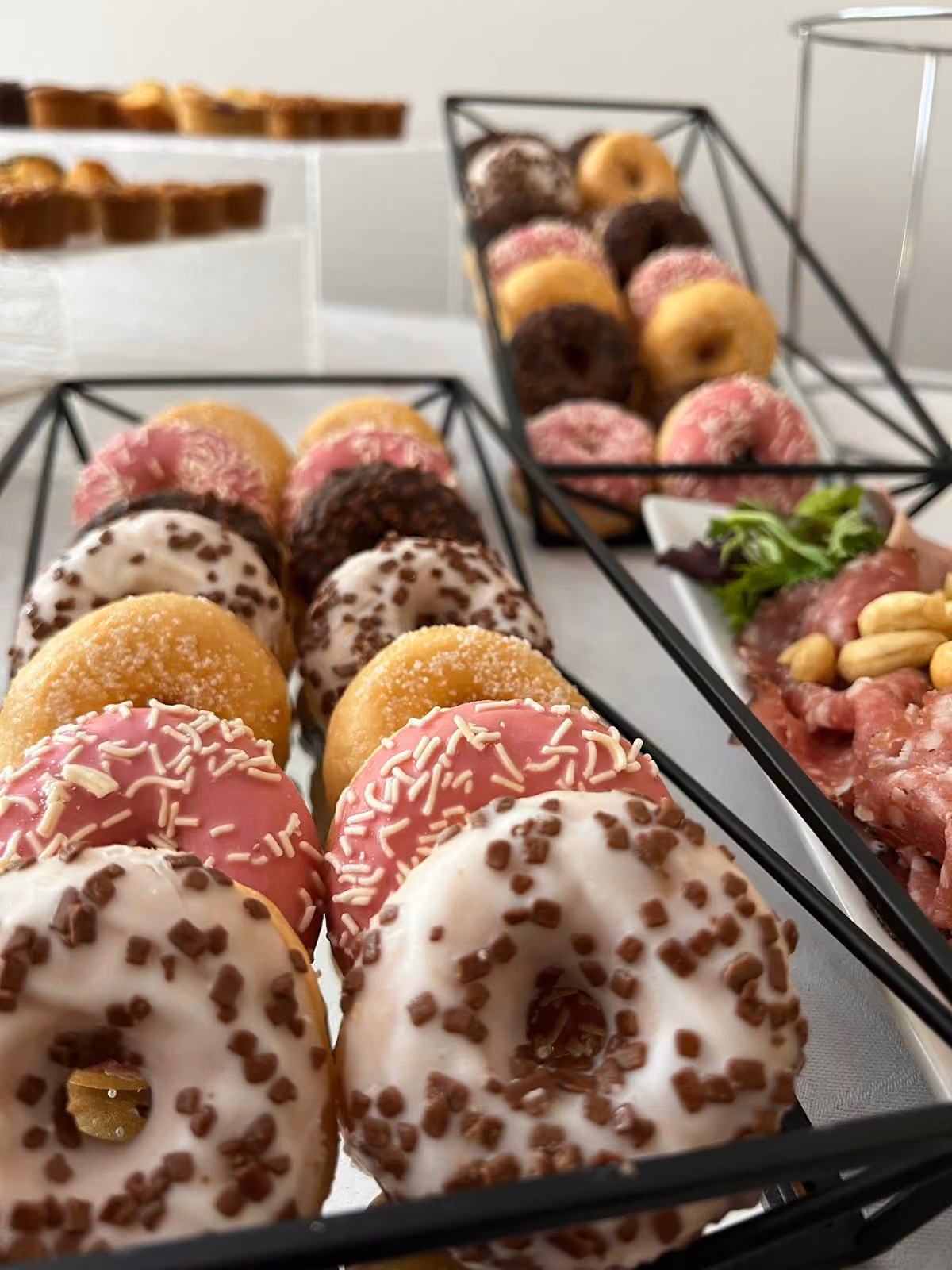 Donuts glacés Donuts glacés roses et chocolat sur un présentoir en métal noir
