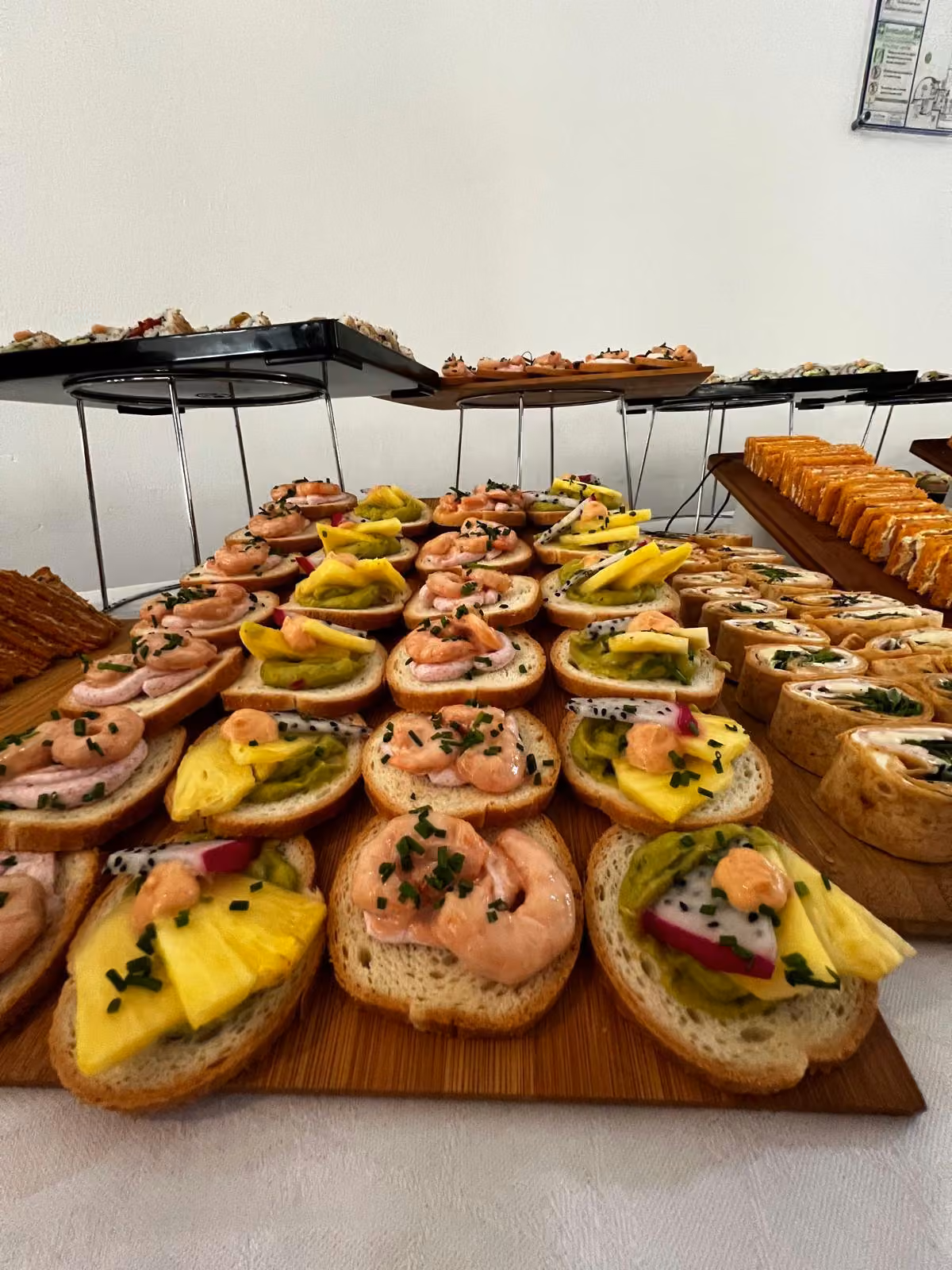 Tartines crevettes et mangue Tartines garnies de crevettes, de mangue et de fruit du dragon sur planche en bois