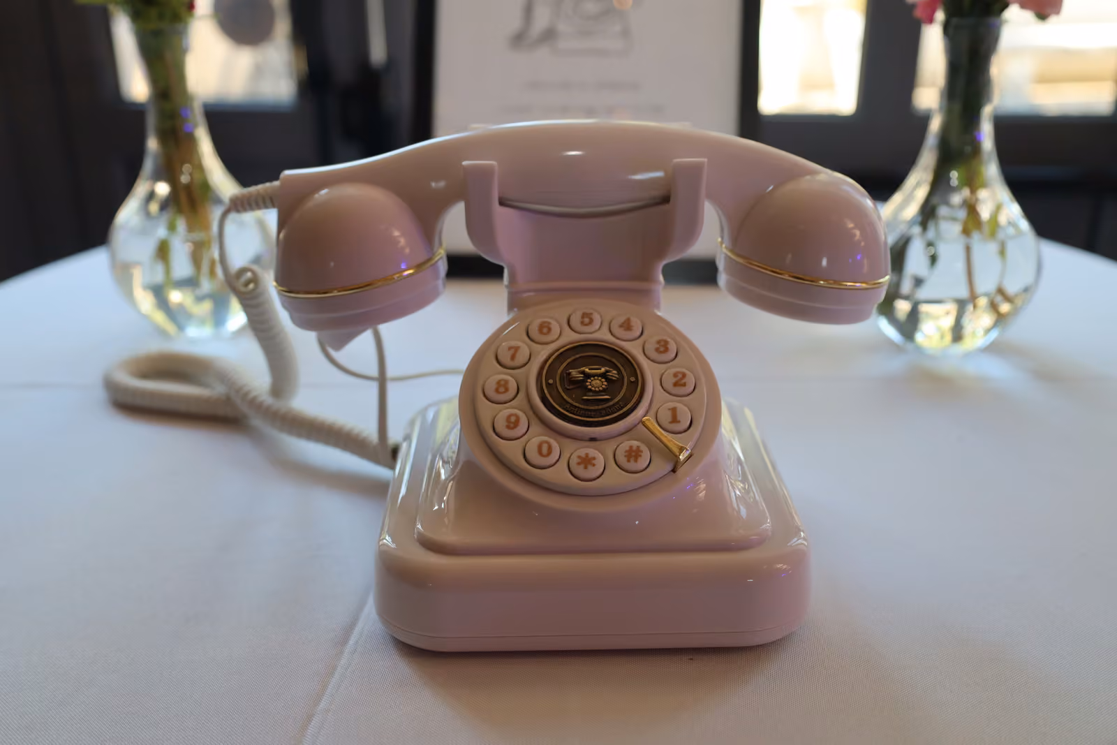 Livre d'or audio de mariage Téléphone rétro rose servant de livre d'or audio, posé sur une table de réception de mariage