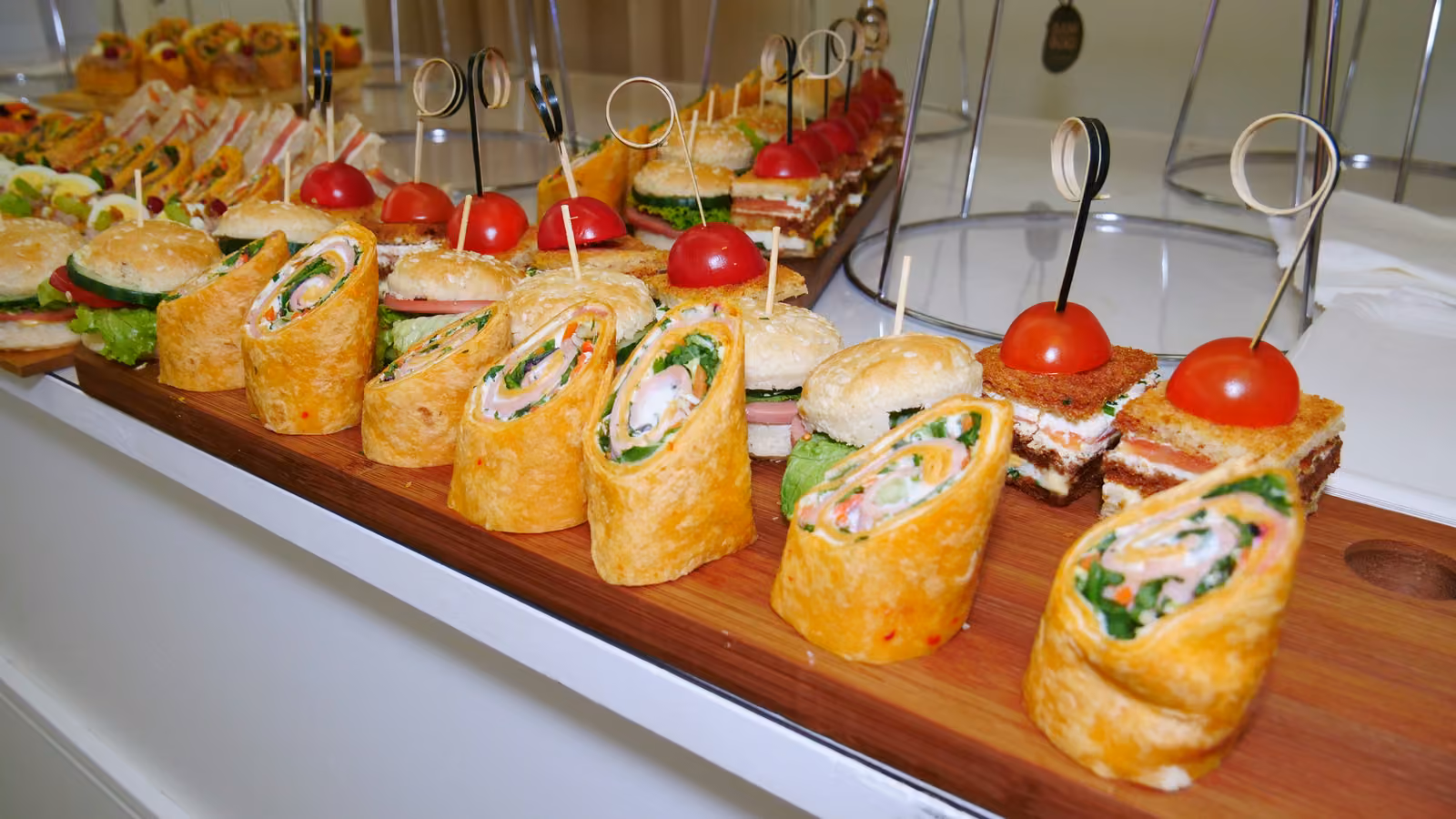Wraps et club-sandwichs Planche de wraps au poulet et de club-sandwichs piqués de tomates cerises